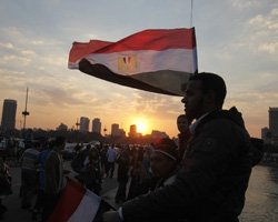 People stand on a bridge overlooking the river Nile.