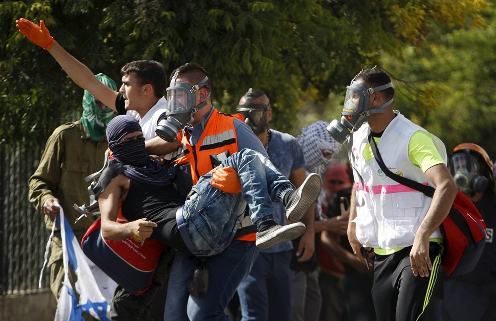 A wounded Palestinian protester is evacuated during clashes with the Israeli troops in the West Bank city of Bethlehem, October 14, 2015. REUTERS/Mussa Qawasma