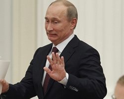 Russian President Vladimir Putin gestures as he arrives for a meeting with G20 summit participants in the Kremlin February 15, 2013. 