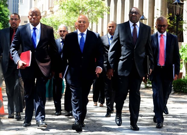 Once-and-current Finance Minister Pravin Gordhan, center, walks with now-former Finance Minister Nhlanhla Nene, left, ahead of a 2014 budget speech. Photo by Government of South Africa, Creative Commons via Flickr.