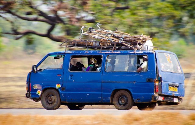A fully-loaded share taxi speeds down a road. In Kenya these taxis, called Matatus, are crucial parts of Nairobi's transportation network. Photo by crosby_cj on Flickr. Creative Commons.