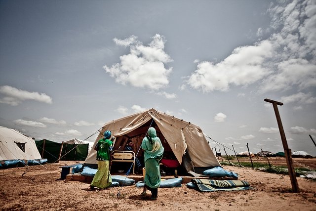 Two women enter a tent at the Mentao refugee camp in Burkina Faso in 2012, a camp formed from people leaving the conflict in Mali. Many African countries host far more refugees and migrants than Europe, and the fates of refugees and migrants are linked to