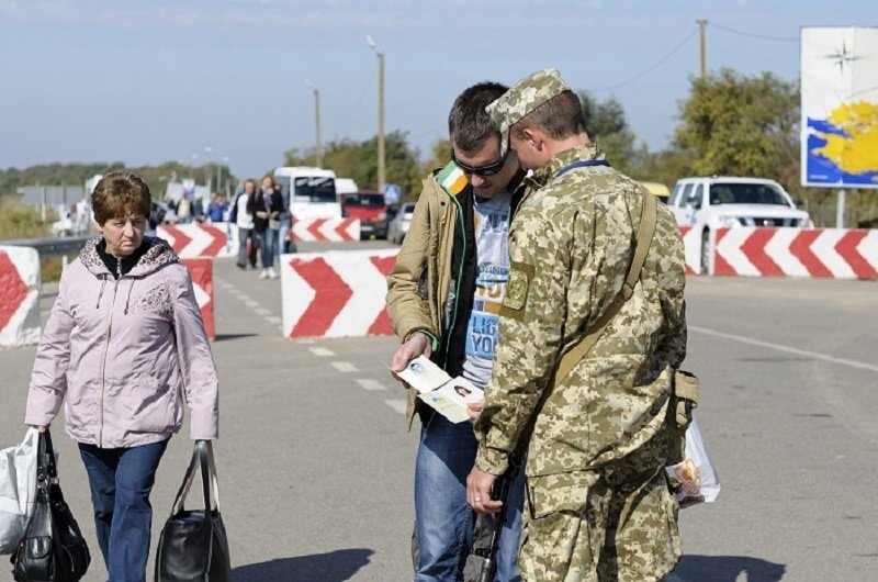 Border guard checking traveler’s passport at the border crossing point Kalanchak. September 20, 2017. Khersonskaya oblast, Ukraine. Source: Shutterstock.