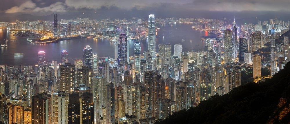 A panorama of the Hong Kong Island and Kowloon skyline at night,