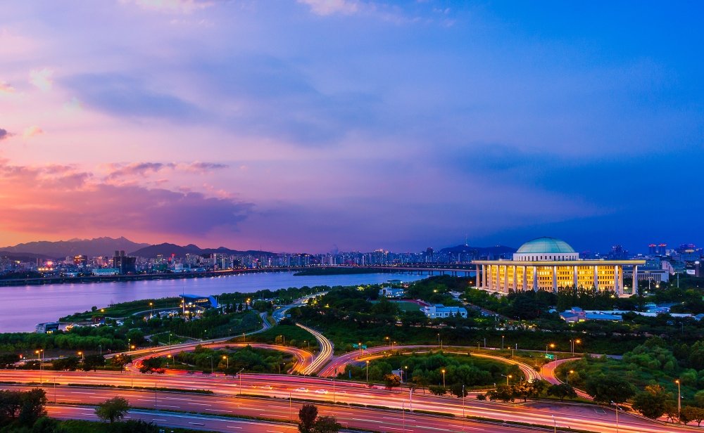A wide shot of the city of Seoul with the National Assembly Building of South Korea in the background, shot at sunset.