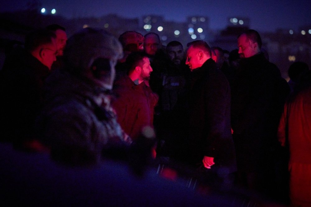 Group of men standing in a cemetery at night