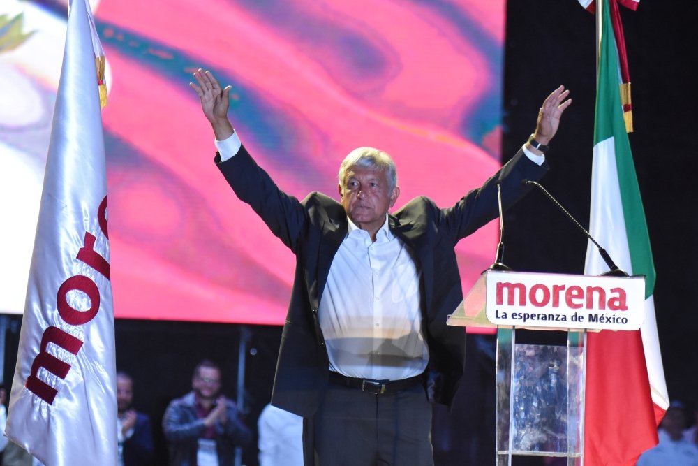 AMLO with his hands up at a Morena rally