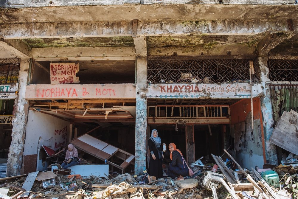 Two women in the ruins of a building in Marawi City, Philippines.