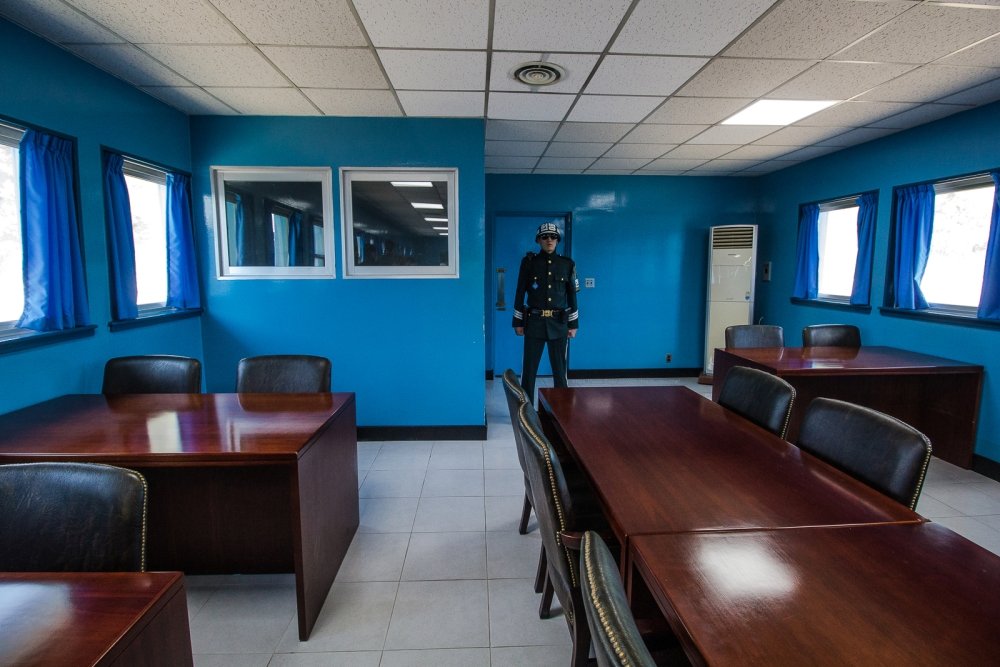 A man stands inside a blue room at the DMZ.