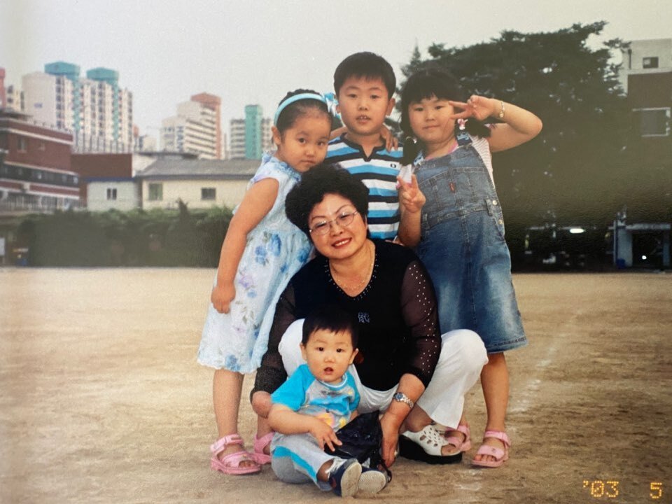 Four young children pose with their grandmother.