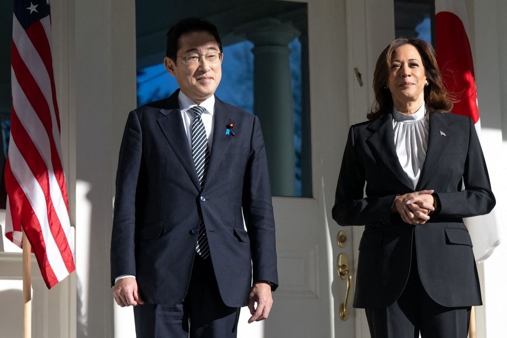 Japanese Prime Minister Fumio Kishida and U.S. Vice President Kamala Harris stand in front of a building.