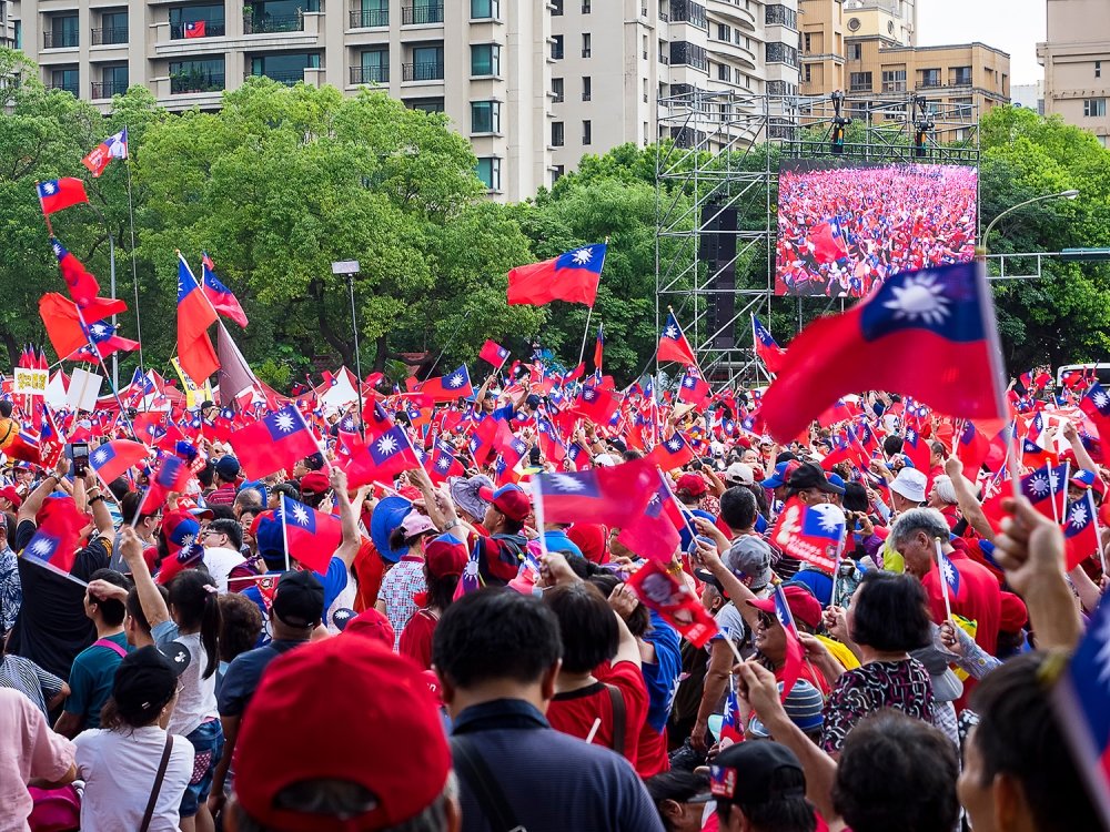 A large crowd at a rally holds up Taiwanese flags.