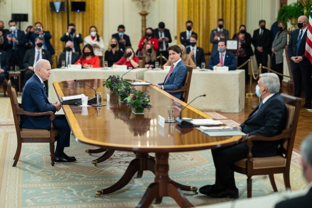 President Biden, President Lopez Obrador, and Prime Minister Trudeau sit at a table and talk