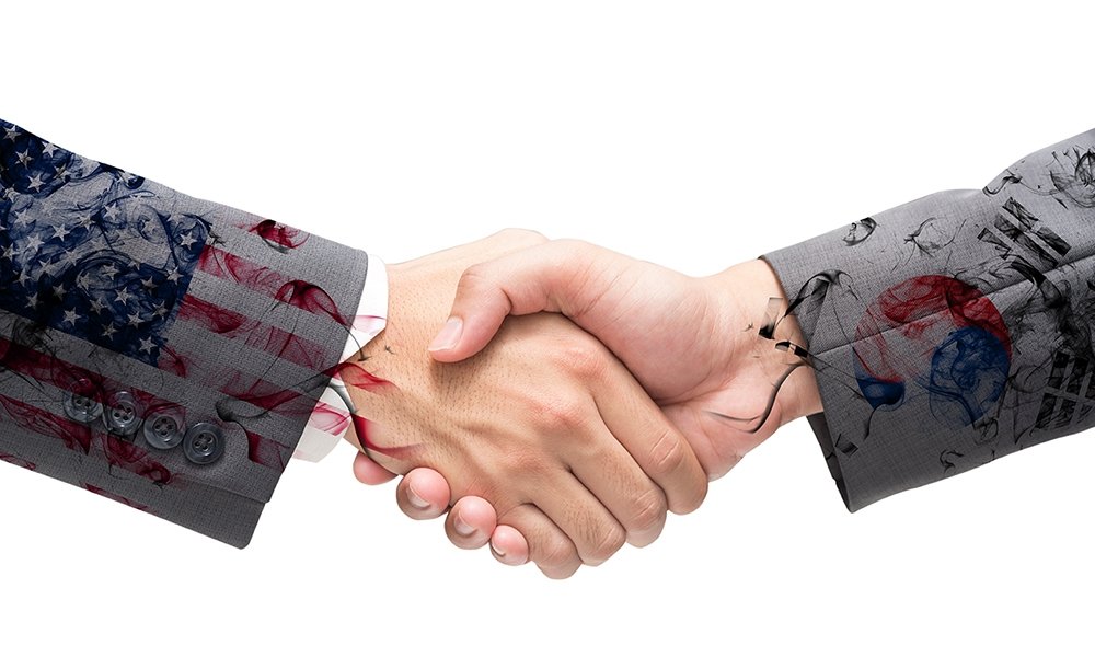Handshake with US and South Korean flags overlaid