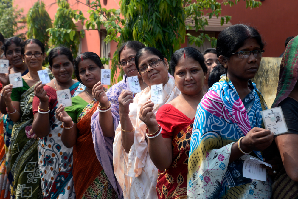 Indian women stand in queue with their Voter ID Card in hand during the West Bengal Three tier Panchayat Election approximate 40 k.m. from state capital Kolkata on May 14, 2018 in Hooghly, India.