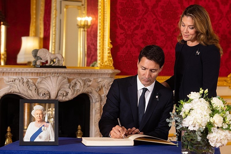 Justin Trudeau signs a book of condolence with his wife Sophie Grégoire-Trudeau at Lancaster House after the death of Queen Elizabeth II.