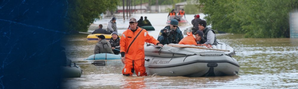 Man walking in knee-high water pulling a raft with people in it