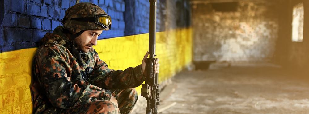 Soldier in front of Ukraine flag wall