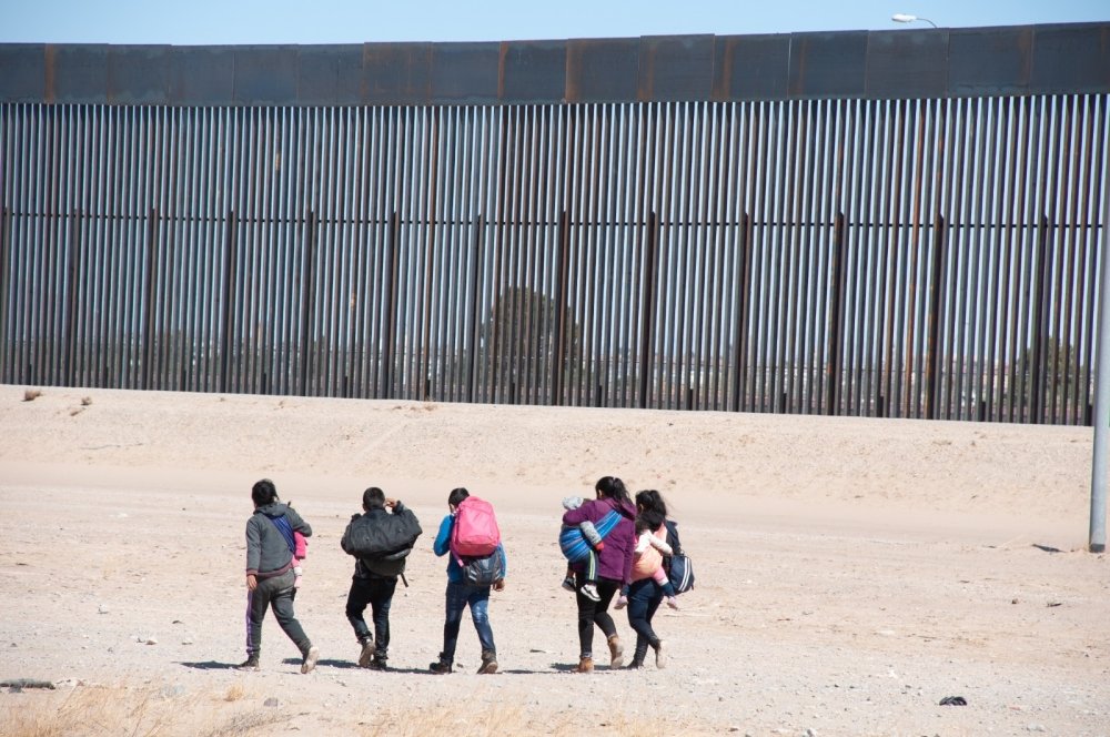 A group of migrants walks near the U.S. border.