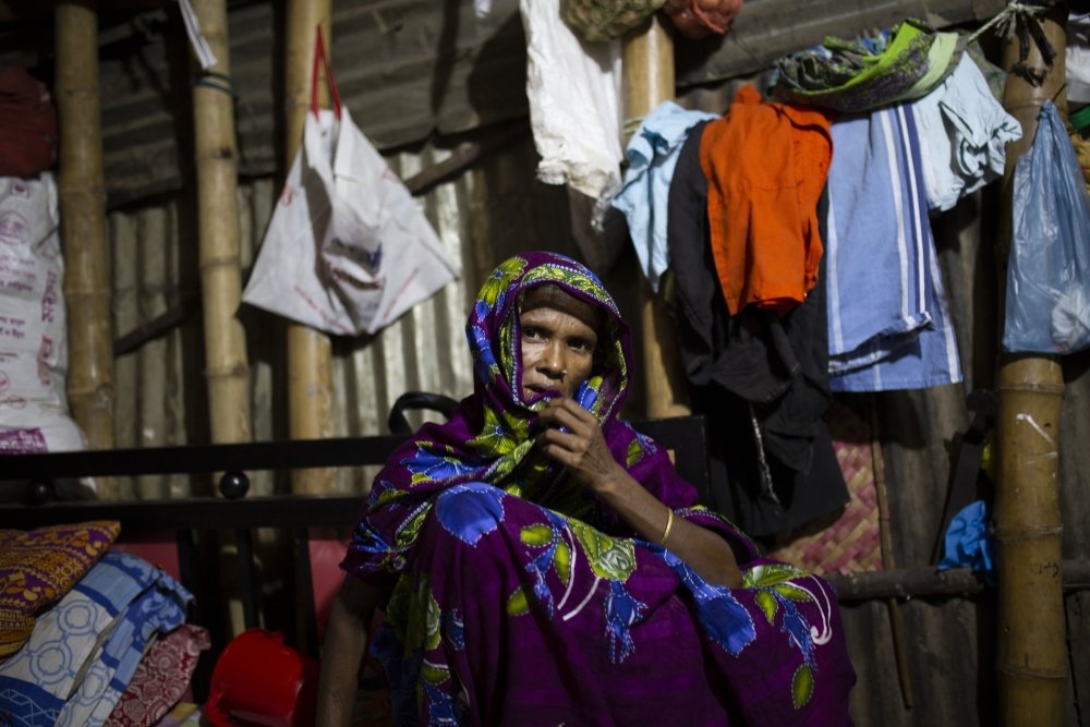 Bangladeshi woman sitting in front of clothing lines