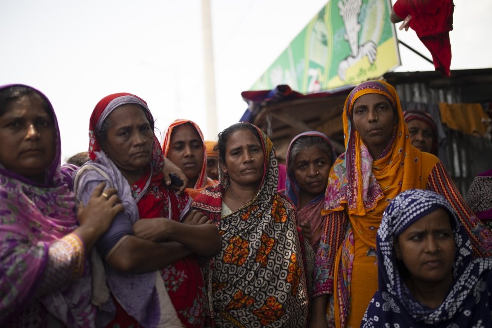 Bangladeshi women stand together outside.