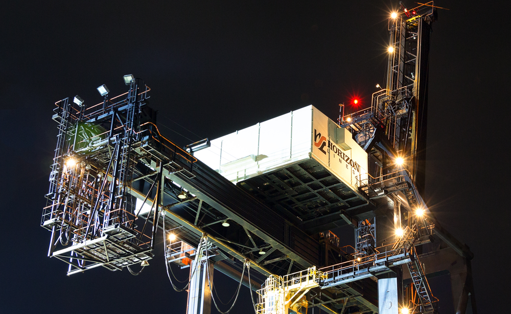 Dutch Harbor, Unalaska, Alaska, USA - August 14th, 2017: Night view of a port crane for shipping containers operated by Horizon Lines located at the port of Unalaska, Alaska