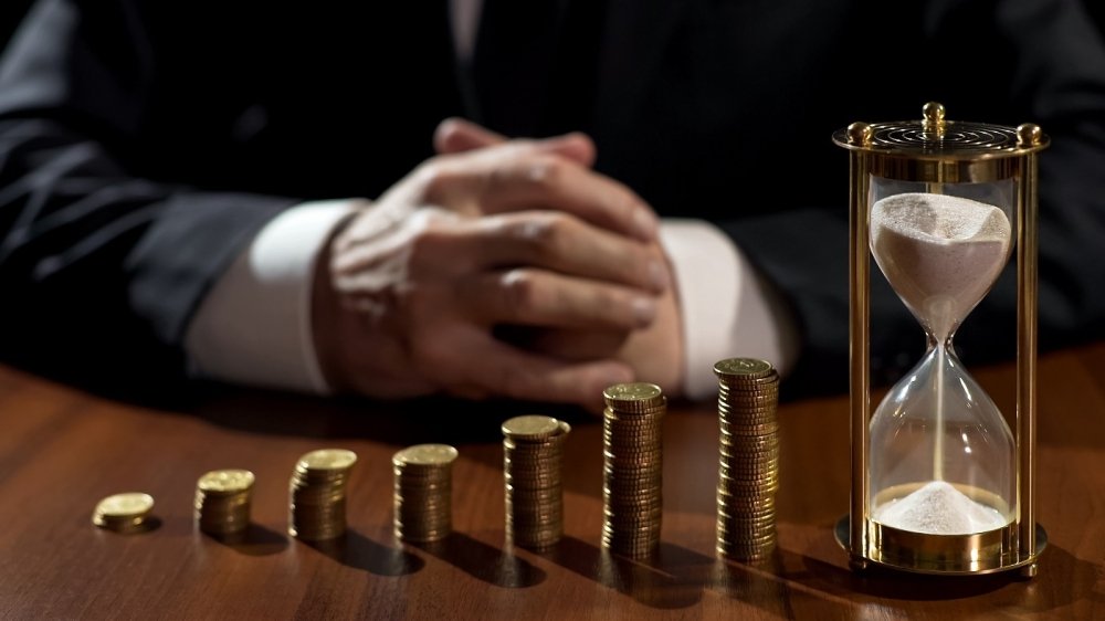 Pile of coins and an hourglass
