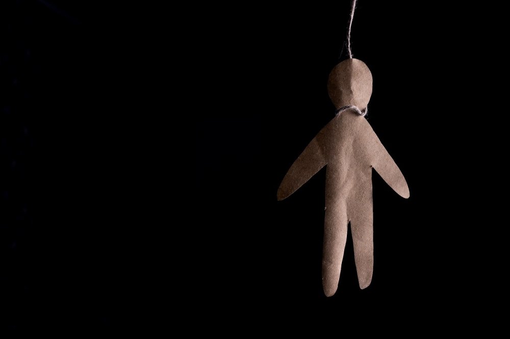 Paper doll hanging by a noose 
