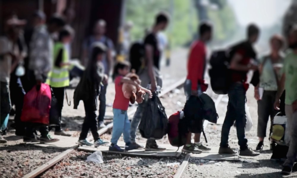 Refugees crossing train tracks in Europe