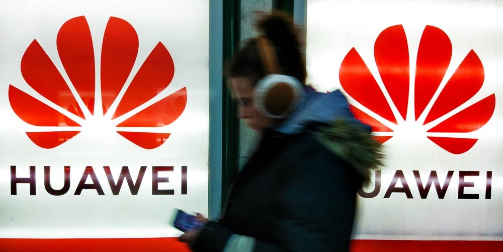 A young woman walks past to advertisement light boxes with Huawei logo in Kiev, Ukraine.
