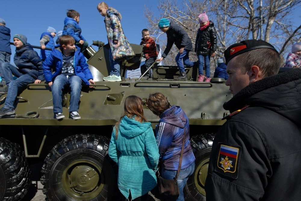 children play on a Russian armored car on the fifth anniversary of the annexation of Crimea