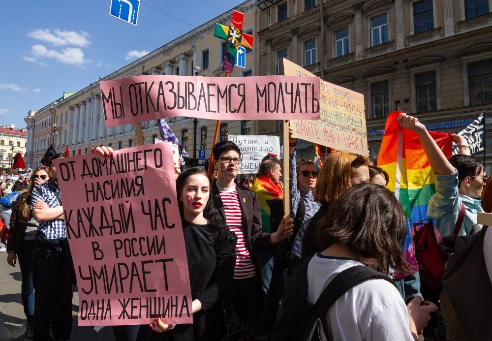 Protesters with the poster "One woman dies every hour of domestic violence in Russia."