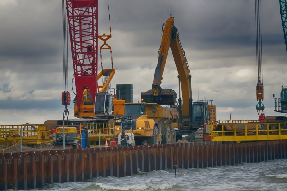 Construction of offshore section of gas pipeline on bottom of Baltic sea Nord stream-2. Pier goes into Narva Bay, excavator aligns bottom under bed of gas pipeline. Auxiliary vessels at sea.