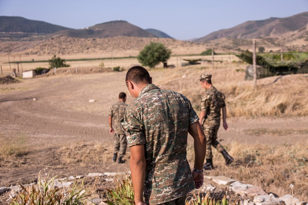 Nagorno-Karabakh, Republic of Artsakh - 08/03/2019 - Three soldiers of the Artsakh Defense Army walking on dirt road in their off time