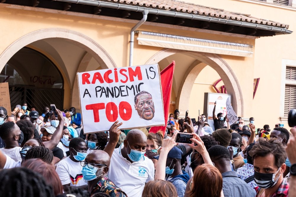 Palma de Mallorca, Spain - June 07 2020: Man surrounded by crowd holding a banner