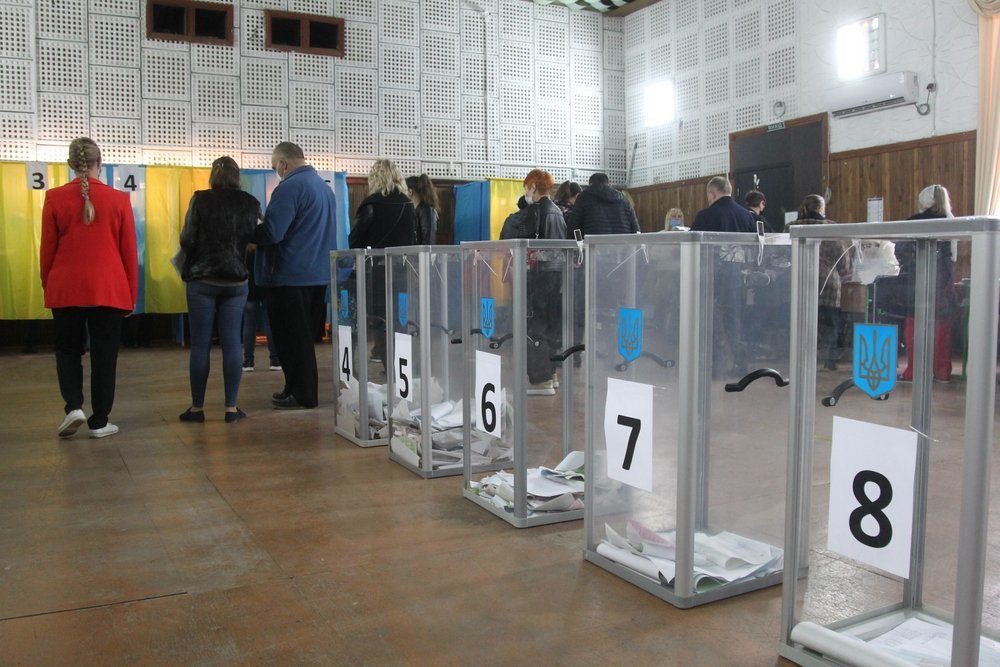 ODESSA, UKRAINE -25.10.2020 - Elections in Ukraine. Electoral platform for elections of local councilors during the COVID-19 coronavirus pandemic. People wearing masks and gloves with voting ballots