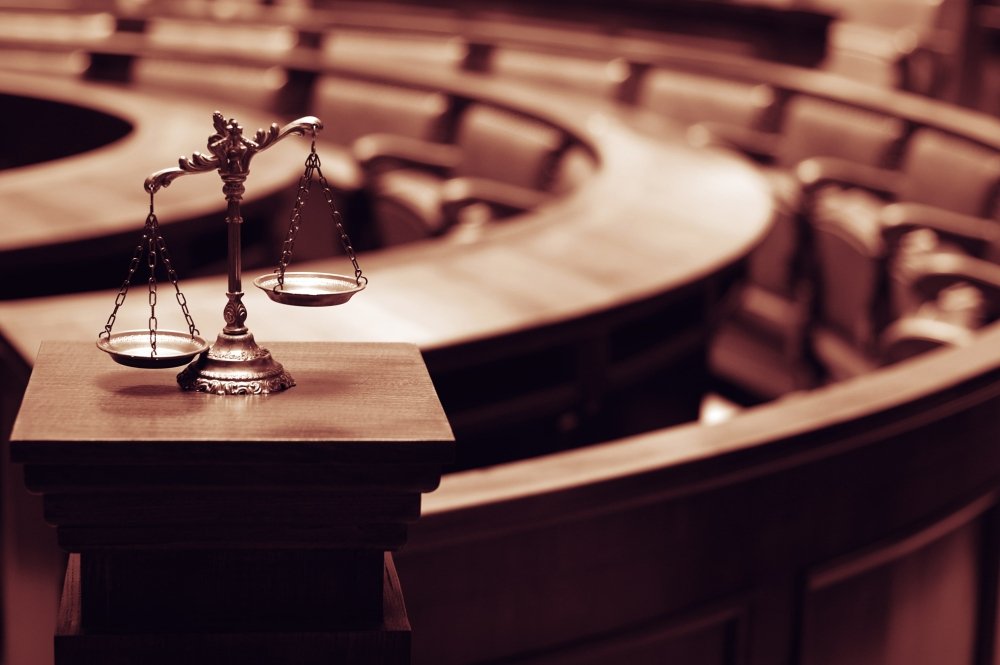 Image of a scale representing justice in front of a court room