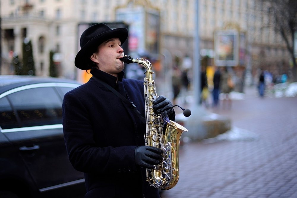street musician, playing saxophone on a street. March 5, 2019. Kiev, Ukraine