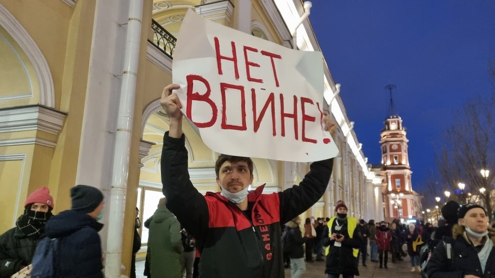 Man holding sign with Russian text declaring "No War"