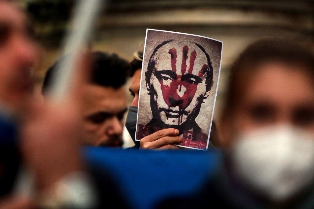 Putin's bloody face on a poster is shown during Ukrainian protesters with candles gather in Piazza del Campidoglio in Rome, against the war operations of Russia in Ukraine