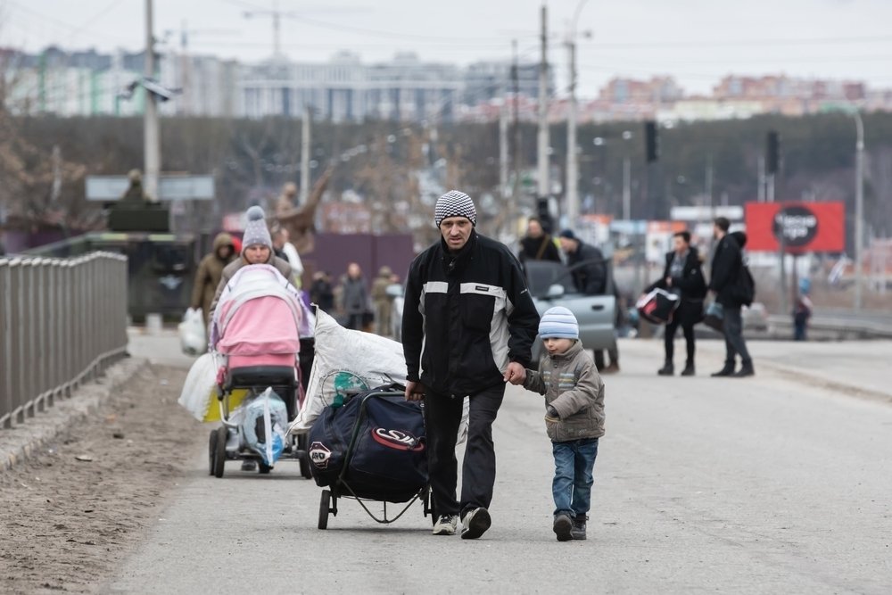 Group with children carrying items down a road