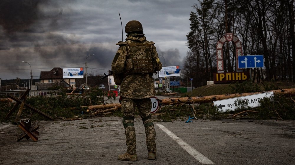 Irpin, Ukraine - 5 March 2022: Ukrainian soldier stands on the check point to the city Irpin near Kyiv during the evacuation of local people under the shelling of the Russian troops.