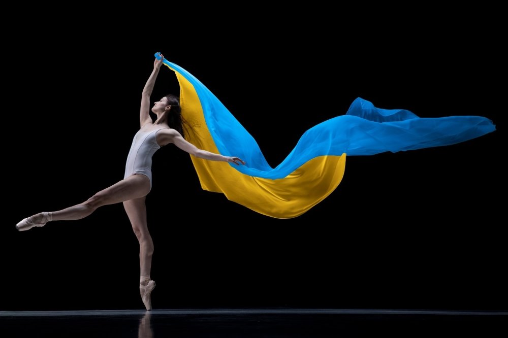 ballerina dancing with cloth painted in blue and yellow colors of Ukraine flag