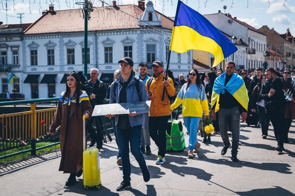 Protesters walking down street with Ukrainian Flags