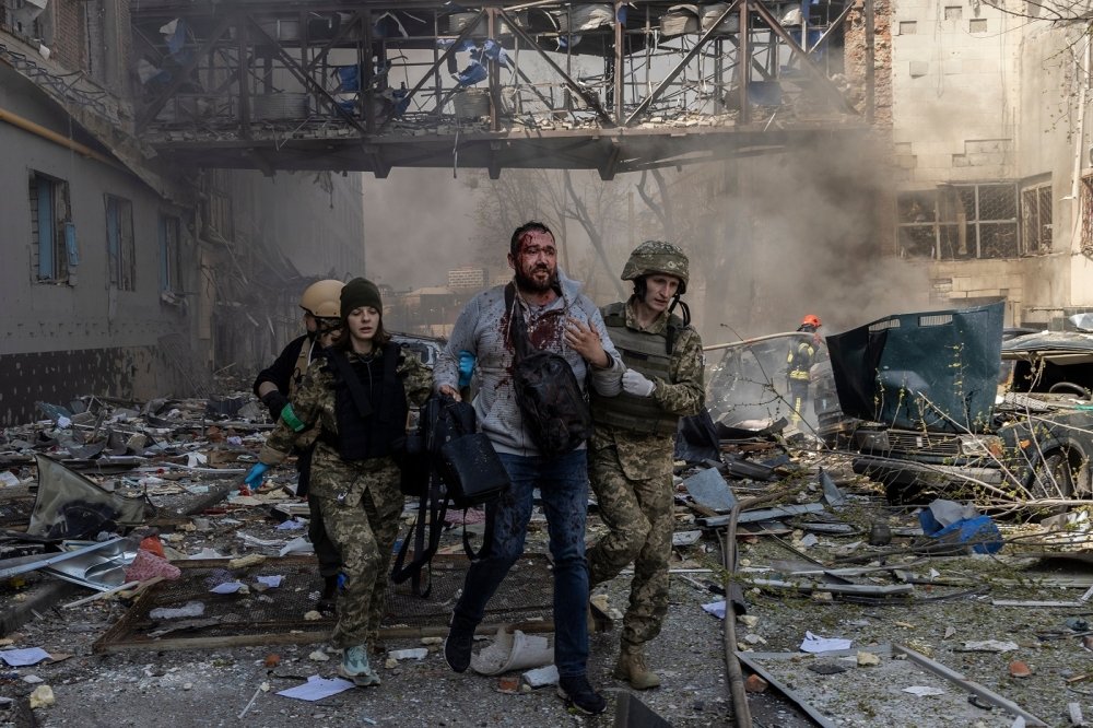 A person is helped by emergency personnel after an attack in a commercial area of Kharkiv 