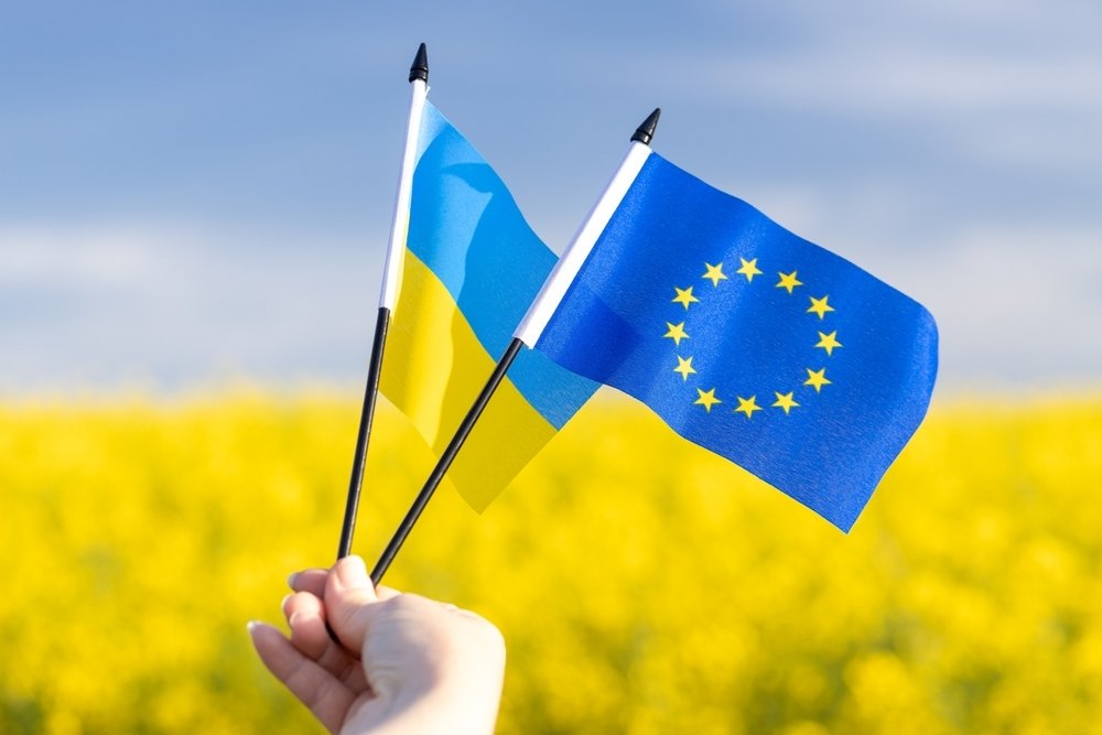 Flags with symbols of the European Union and Ukraine held in a girl's hand, Concept, Acceptance of the Ukrainian candidacy to apply for EU membership