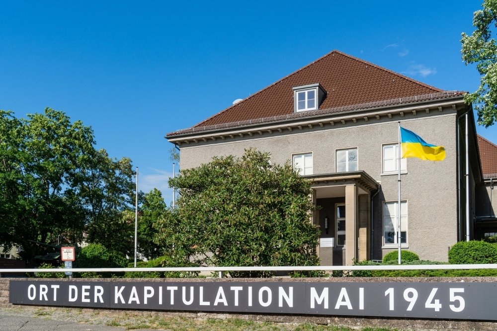 The Berlin-Karlshorst Museum with sign stating "Place of Surrender May 1945" and flying the flag of Ukraine