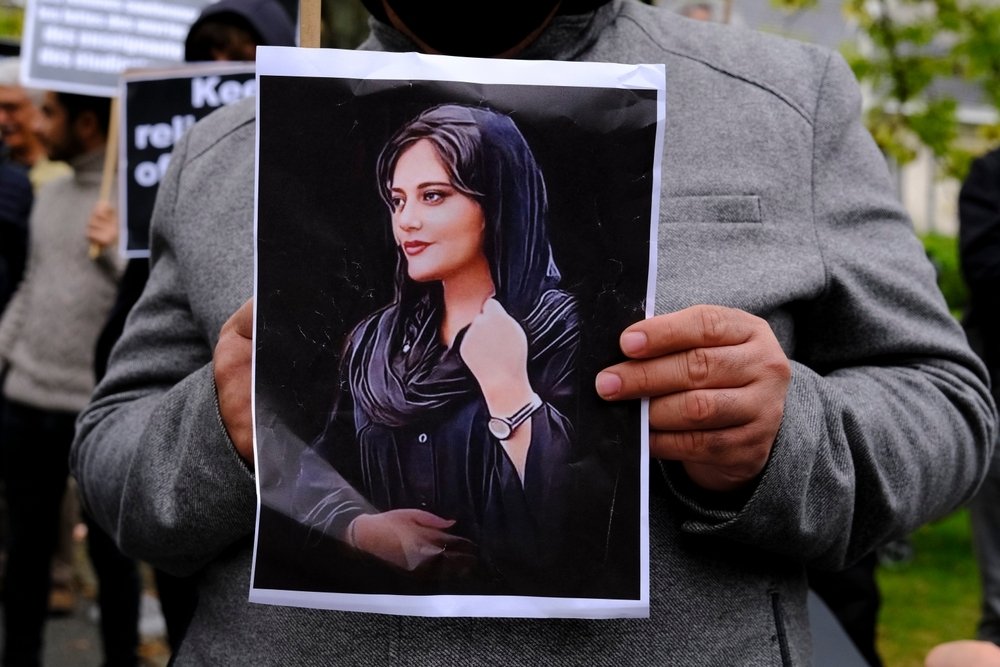 Protester holding photo of Mahsa Amini