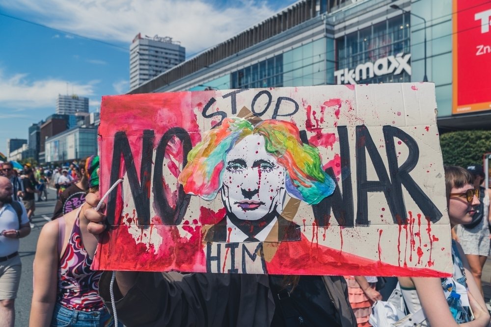 Sign at Polish protest depicting Putin as a clown with the caption "Stop Him--No War"