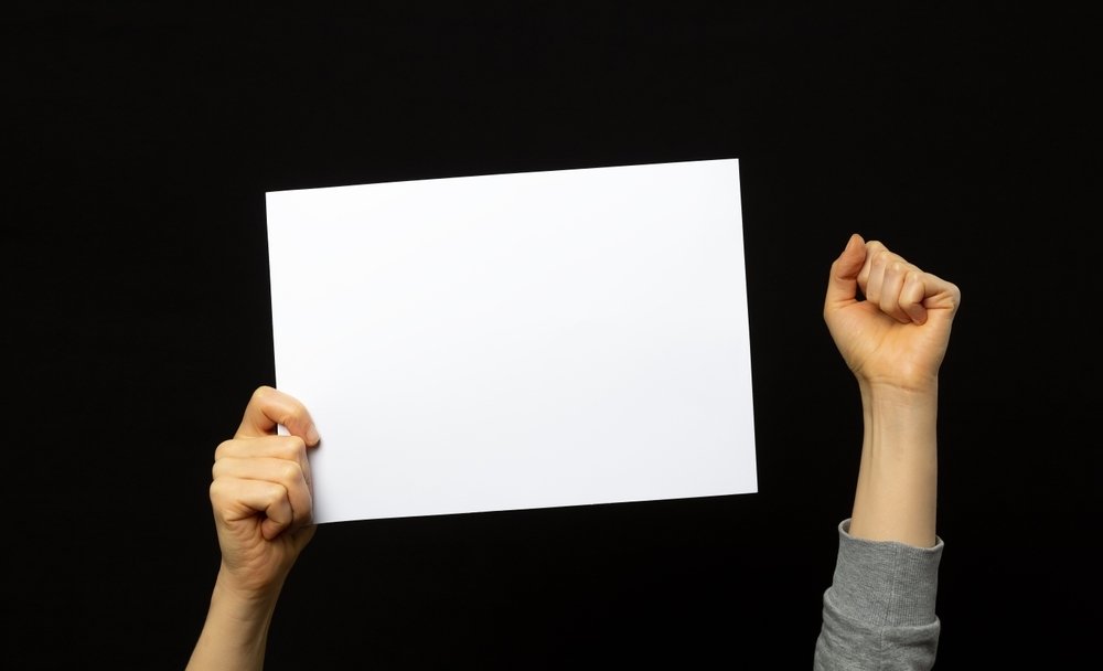 A hand holds up A Blank Placard